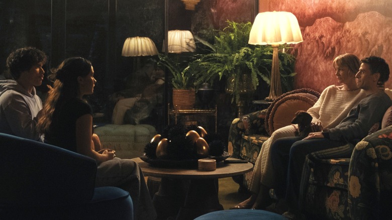 Oscar Isaac as Josh Martín and Carey Mulligan as Lindsay Crane-Martín sitting on a sofa opposite Cailee Spaeny as Ashely Miller and Charles Melton as Austin Davis in Beef