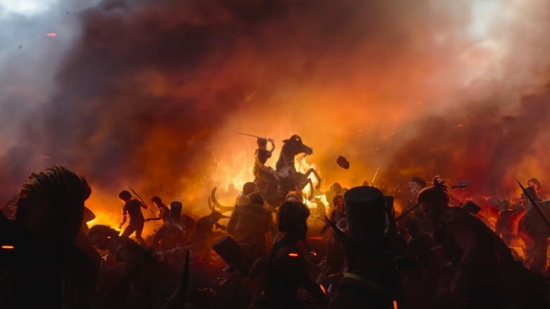 A horse rearing up during battle as flames rage in the background in Wildwood