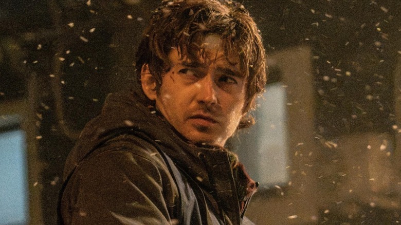 Austin Abrams as Bryan holding a machine gun in the snow in Resident Evil (2026)