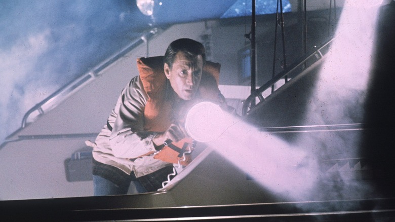 Sheriff Brody shines light through a dark fog in the water in the chin