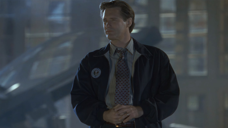 Le président de Bill Pullman, Thomas J. Whitmore, se tient dehors devant un avion de combat le jour de l'Indépendance.