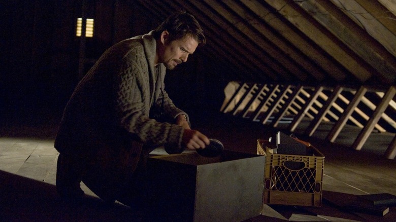 Ethan Hawke as Ellison as he finds the box of movies in the attic in Sinister