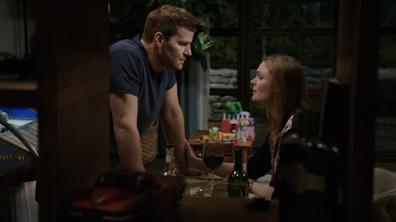 David Boreanaz's Seeley Booth leans across a table as he talks to Emily Deschanel's Temperance Brennan in Bones