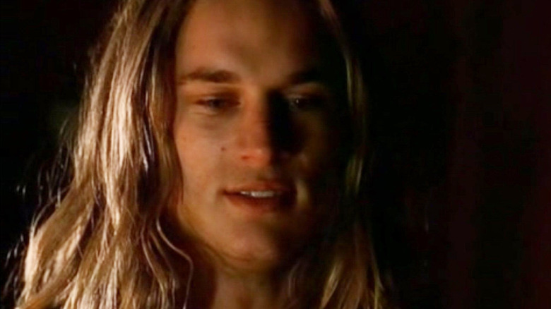 Travis Fimmel as Tarzan standing in the dark in Tarzan (2003)