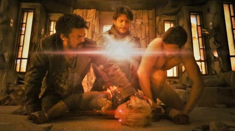 Butcher and Hughie holding down Homelander while Soldier Boy loads up an energy blast in The Boys