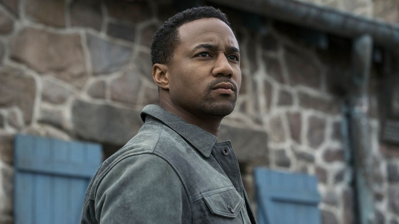 Jessie T. Usher as Reggie Franklin, looking out from a shack in The Boys.