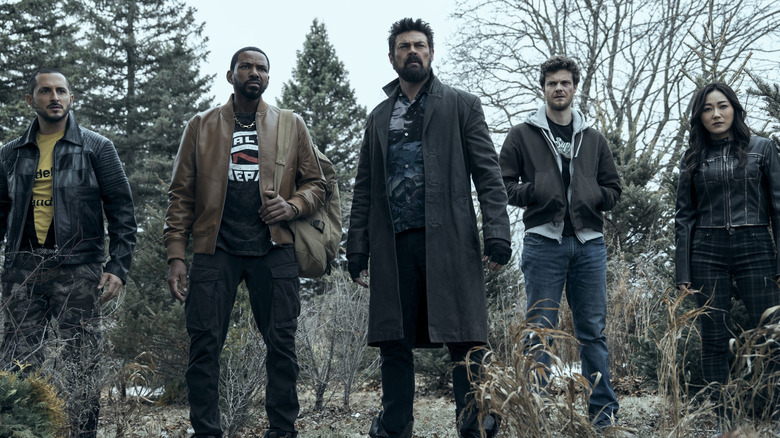 Tomer Capone as Frenchie standing in a wooded area next to Laz Alonso as MM, Karl Urban as Billy Butcher, Jack Quaid as Hughie Campbell, and Karen Fukuhara as Kimiko in The Boys