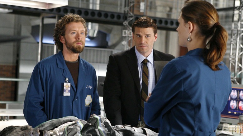 Hodgins, Booth e Brennan em volta de um cadáver em Bones