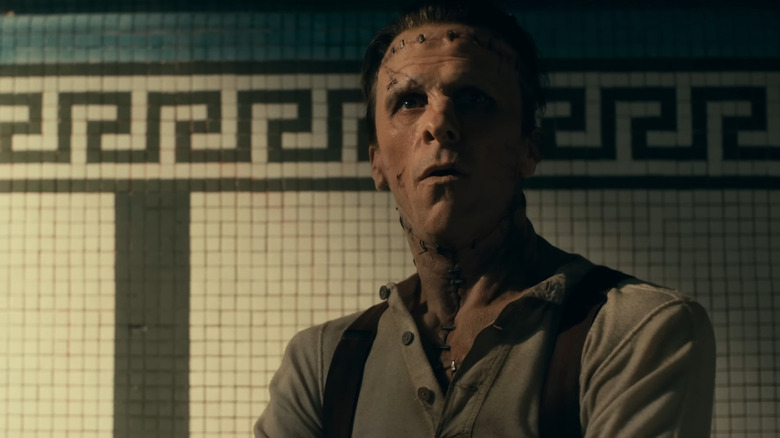 Christian Bale as Frankenstein against a tiled wall in The Bride!