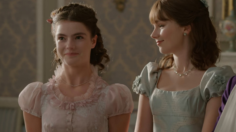 Eloise (Claudia Jessie) smiling at beaming Hyacinth (Florence Hunt) in Bridgerton
