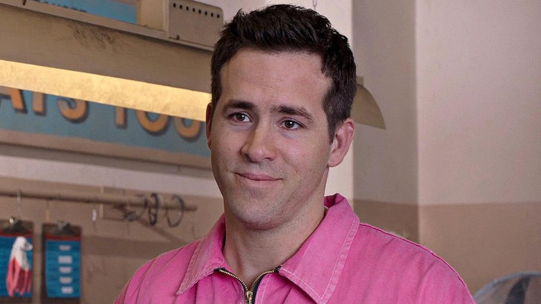 Ryan Reynolds as Jerry Hickfang smiling while wearing a pink shirt in The Voices