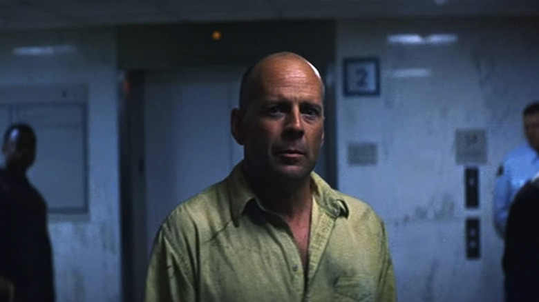 David Dunn stands in a hospital in Unbreakable and looks into the camera