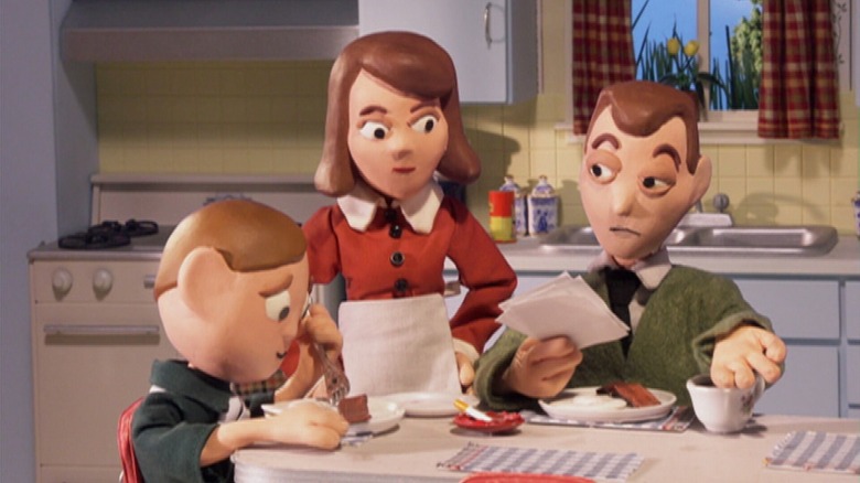 Orel Puppington holds a fork while eating at the dinner table while his father Clay and mother Bloberta share an upset look at each other in 
