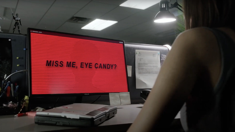 A woman stares at a computer screen reading Miss Me, Eye Candy? in black font against a red background in Eye Candy