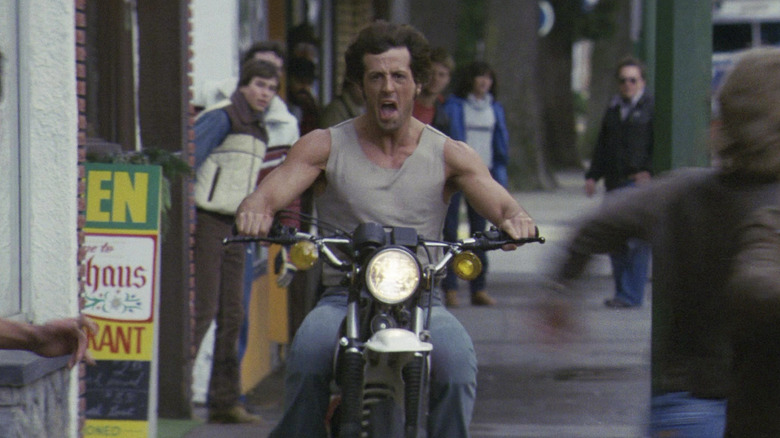 Sylvester Stallone as John Rambo screaming as he rides a motorbike in First Blood