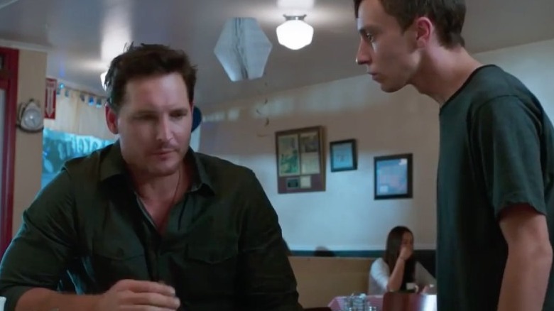 Peter Facinelli seated and looking down