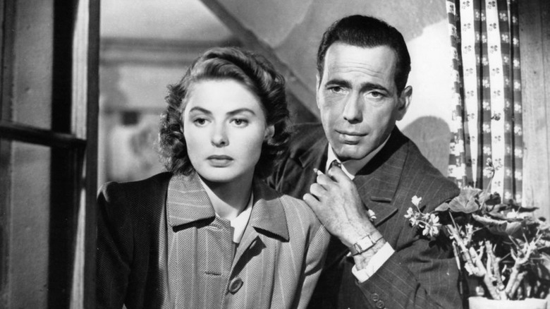 Ingrid Bergman and Humphrey Bogart peer from a window
