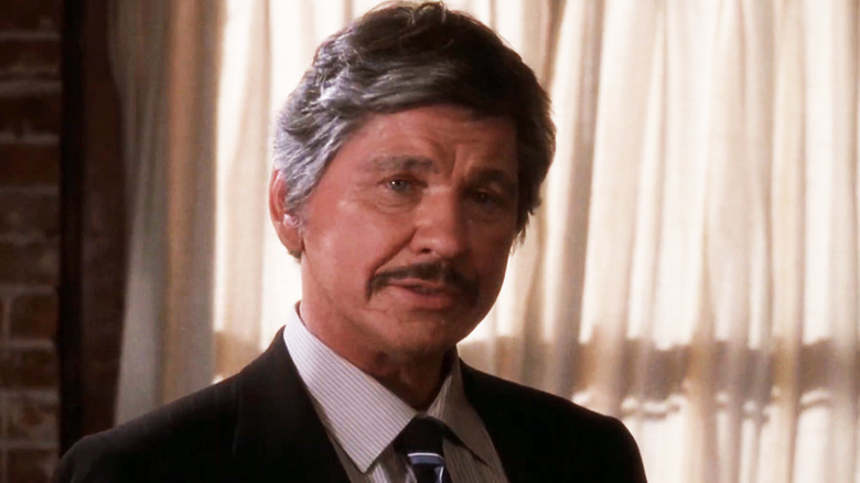 Charles Bronson's Detective Leo Kessler stands in front of some curtains in 10 to Midnight