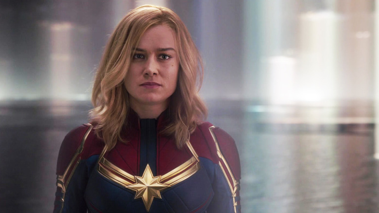 Brie Larson's Captain Marvel stands amid a blurry environment in Captain Marvel