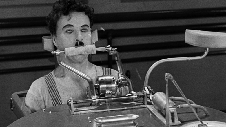 A factory worker being mechanically fed in Modern Times