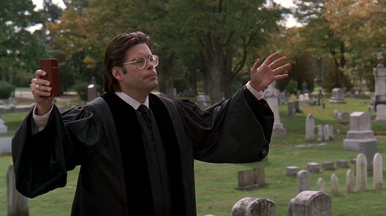 A minister giving final rites at a funeral in Pet Sematary