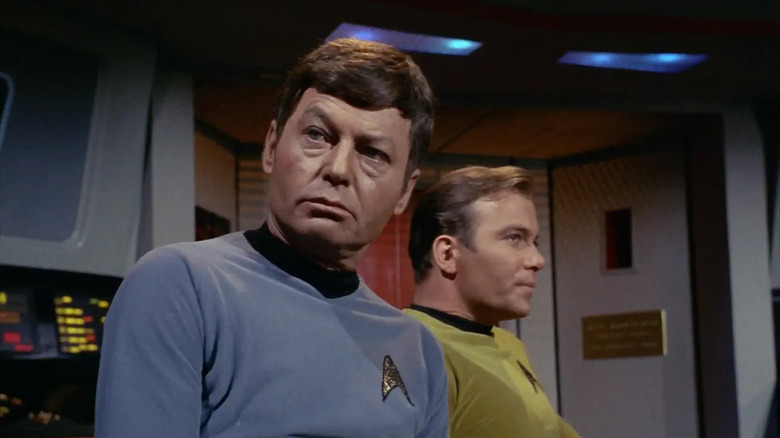 Bones and Kirk standing together on the deck of the U.S.S. Enterprise in Star Trek: The Original Series