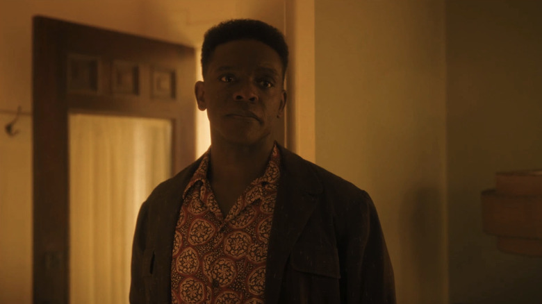 Chris Chalk's Dick Hallorann stands in a doorway in a house in It Welcome to Derry