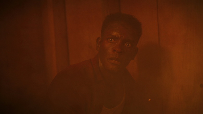 Chris Chalk's Dick Hallorann looks shocked as he sits in a fire in It Welcome to Derry