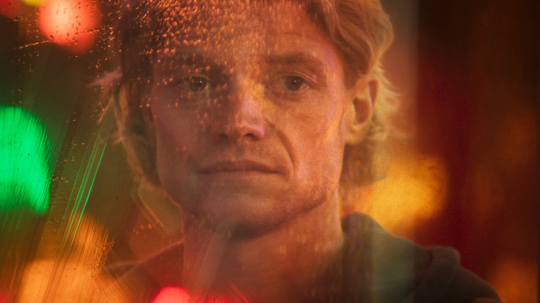 மேட் ஹேகனாக டாம் ரைஸ் ஹாரிஸ் க்ளேஃபேஸில் ஜன்னலில் தன்னைப் பார்த்துக் கொள்கிறார்