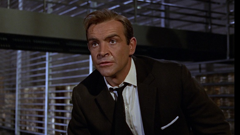 Sean Connery's James Bond looks across frame during a fight in Fort Knox in Goldfinger