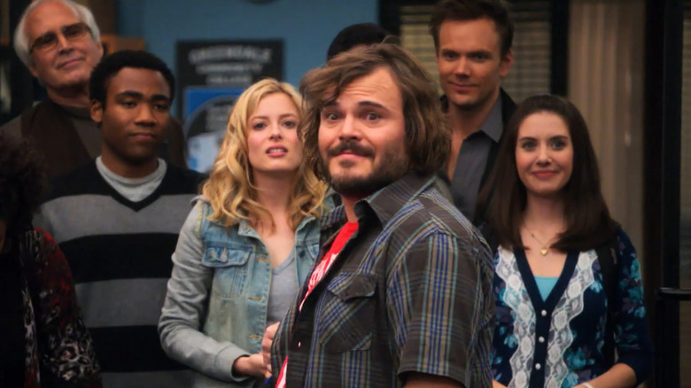 Buddy (Jack Black) turning around, with the study group standing behind him, in Community