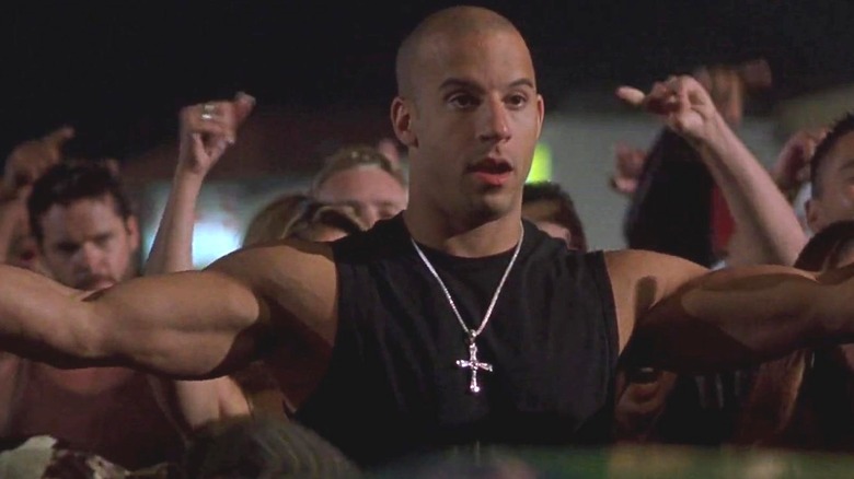 Fast and Furious' Dom with arms spread wide and crowd behind him