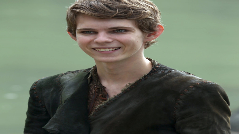 Robbie Kay as Peter Pan, smiling in a field of grass on Once Upon A Time