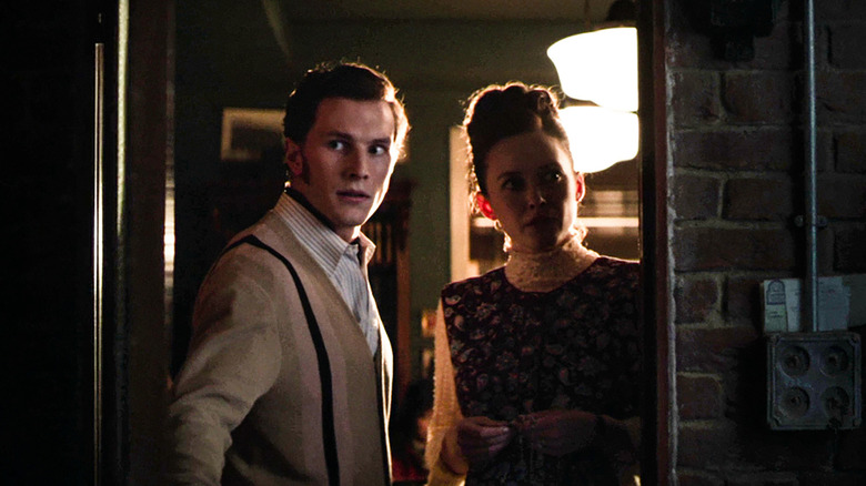 Orion Smith as young Ed Warren and Madison Lawlor as young Lorraine Warren standing in a doorway in The Conjuring: Last Rites