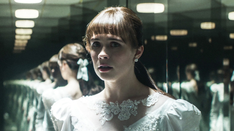 Madison Lawlor as young Lorraine Warren wearing a wedding dress in a room full of mirrors in The Conjuring: Last Rites