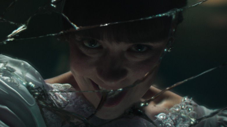 Judy Warren grinning behind broken glass in The Conjuring: Last Rites