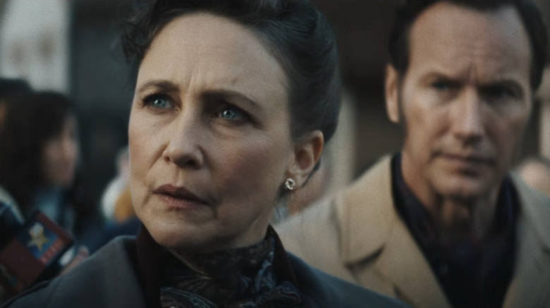 Vera Farmiga as Lorraine Warren and Patrick Wilson as Ed Warren standing among a crowd in The Conjuring: Last Rites