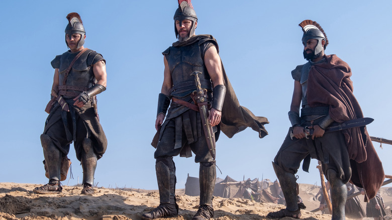 Matt Damon as Odysseus standing on a hill next to Jimmy Gonzales as Cepheus and Himesh Patel as Eurylochus in The Odyssey