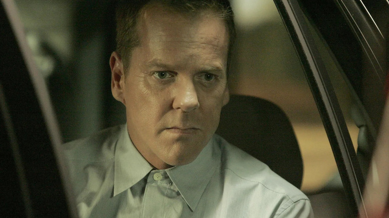 Jack Bauer who looks intense on a major plan sitting in the car 24