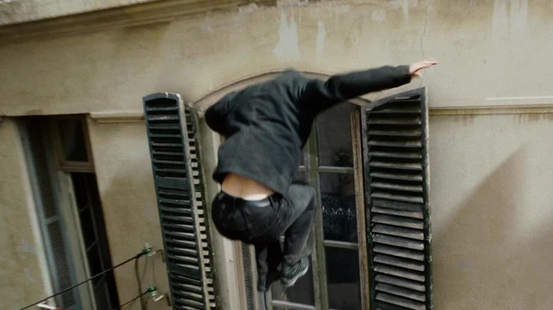 Matt Damon as Jason Bourne jumps towards a window in The Bourne Ultimatum