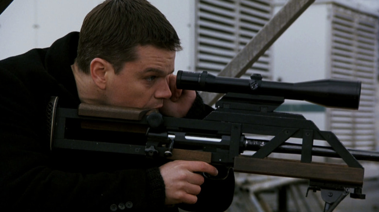 Matt Damon as Jason Bourne aims a sniper rifle in The Bourne Supremacy