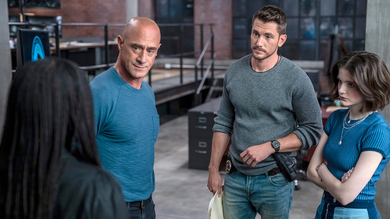 Detective Stabler, in a t-shirt, surrounded by younger cops in an episode of Law & Order: Organized Crime.