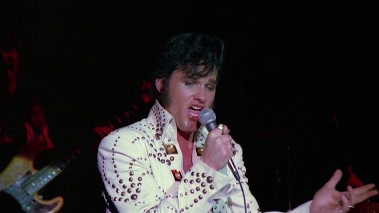 Kurt Russell sports a white, rhinestone suit as Elvis Presley in Elvis