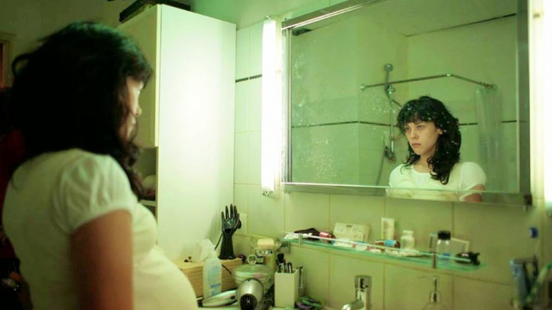 A woman looks in the mirror