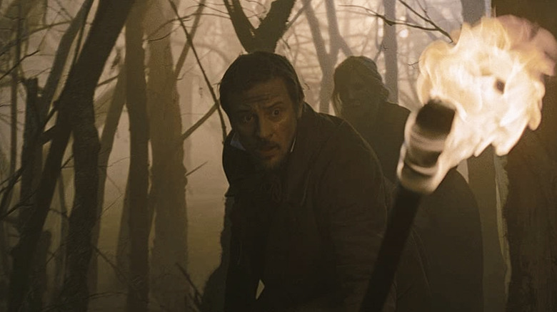 Boyd Holbrook holding a torch in The Cursed