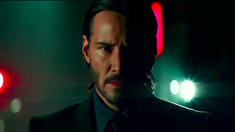 John Wick Faces the Camera with Half His Face in Shadow