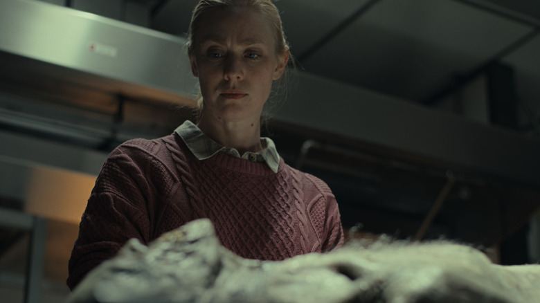 Meg looks at a dead body in a morgue in The Cycle