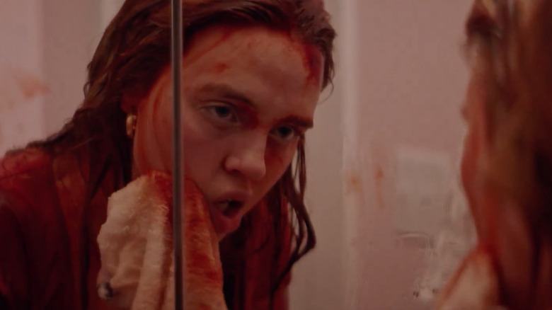 Odessa Young wipes blood off her face in Assassination Nation