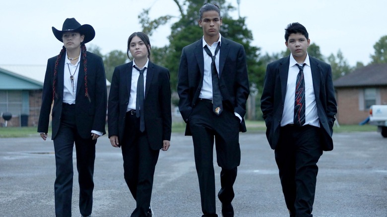 Four teens walking black suits
