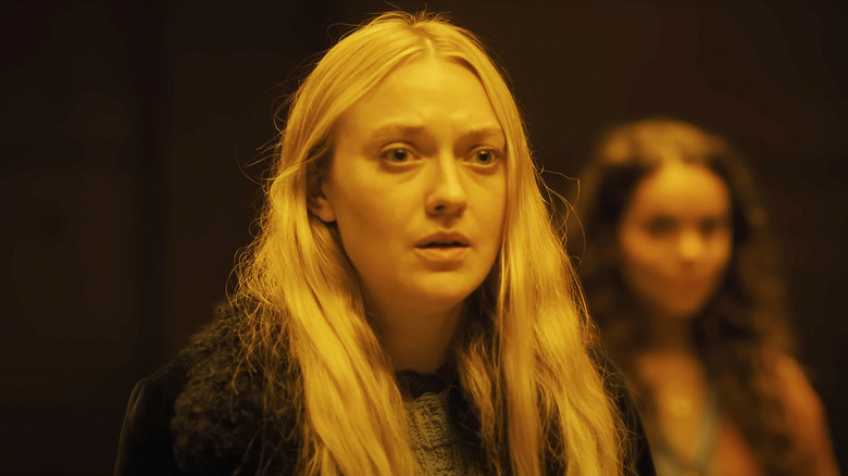 Dakota Fanning's Mina/Lucy looks scared as she's illuminated by yellow light in The Watchers